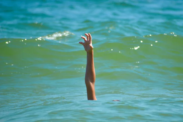Juegos de peligro en el mar. Niño se ahoga en el agua . — Foto de Stock
