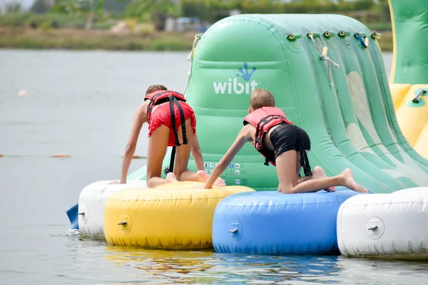 Children in life jackets on inflatable water attraction . — Stock Photo, Image