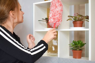 Ev hanımı toz temizliyor. Evdeki düzeni ve temizliği sağlamak. Fırçalı kız