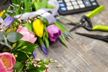 Çiçekçide, ahşap bir masanın üzerinde taze, güzel bir buket lale.