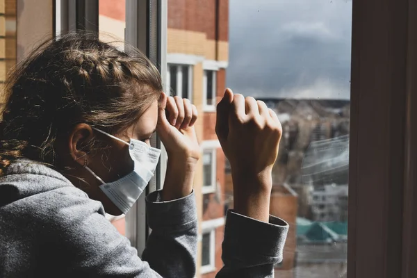 La chica tristemente mirando por la ventana. Quédate en la casa. Aislamiento en casa. infección por virus . —  Fotos de Stock