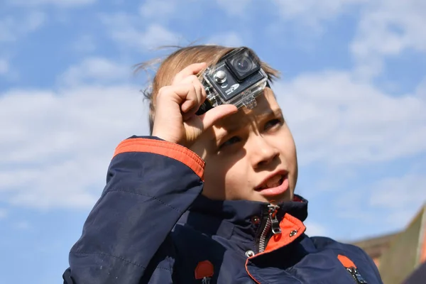 Child shoots video autdoor. The camera on the forehead — Stock Photo, Image