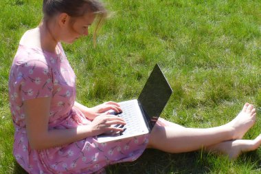 Uzaktan çalışan kız. Bilgisayarla temiz havada serbest çalışan biri.