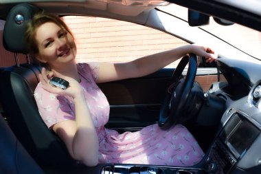 Buying and selling a car. Beautiful young woman driving.