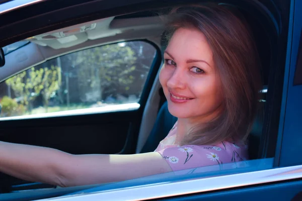 Piękna dziewczyna siedząca w czarnym samochodzie. Przyjemność z jazdy samochodem. — Zdjęcie stockowe