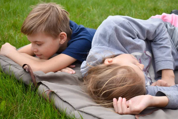 Дети спят на одеяле на лужайке. Брат и сестра заснули на открытом воздухе. — стоковое фото