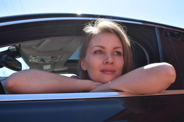 Yeni bir arabanın sahibi. Pahalı arabadaki sarışın kadın. Kız pencereden dışarı bakıyor.