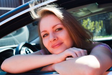 Yeni bir arabanın sahibi. Pahalı arabadaki sarışın kadın. Kız pencereden dışarı bakıyor.