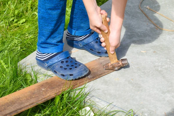 Chico aserrando madera. Un chico trabaja en el jardín. Taller para niños afuera —  Fotos de Stock