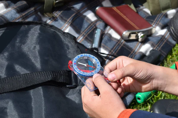 Compass in the hand of a child traveler. Orienteering. Hiker boy going camping. — Stock Photo, Image
