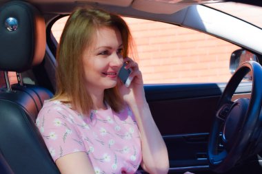 Online communication. The girl in the car talking on the phone.