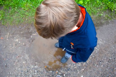 Köylü çocuk atladı. Yoldaki bir su birikintisinde. İnternet olmadan mutlu bir çocukluk.