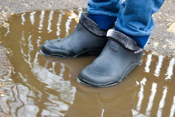 Village boy jumped. in a puddle on road. A happy childhood without Internet — Stock Photo, Image