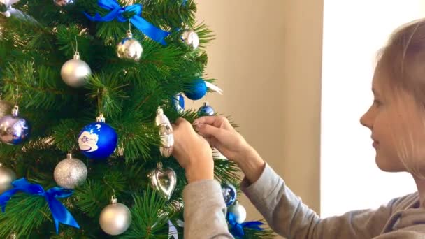 Celebración de año nuevo. Chica usando decoraciones en el árbol en casa — Vídeos de Stock