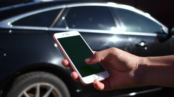 Hand med telefon på bakgrunden av bilen. Sök efter bilinformation på Internet. — Stockvideo