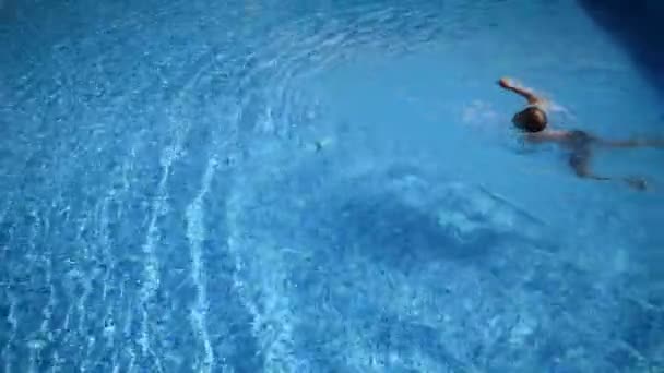 Den unge simmaren är en idrottsman i poolen. simlektioner barn — Stockvideo