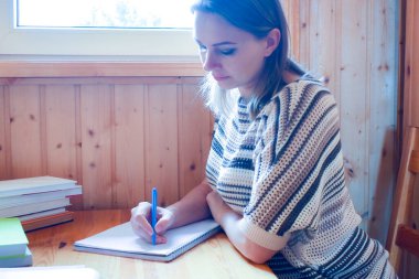 Evde kendi kendini eğitme. Güzel kız odada akıllı kitaplar okuyor..