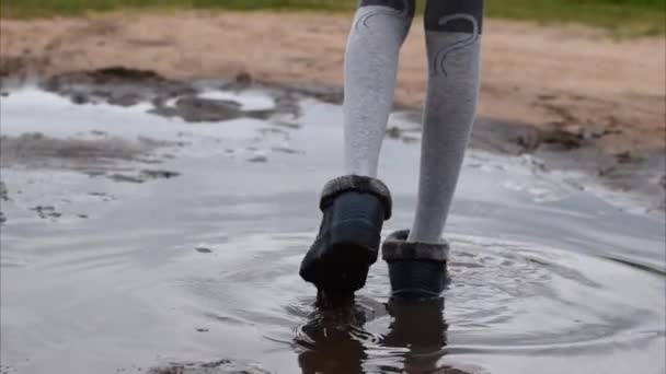 Chica camina a través de un charco en el suelo en el verano. Niños sin artilugios . — Vídeos de Stock