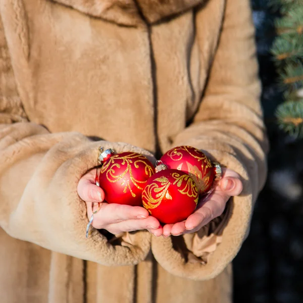 Vrouw met drie rode kerst ballen close-up — Stockfoto