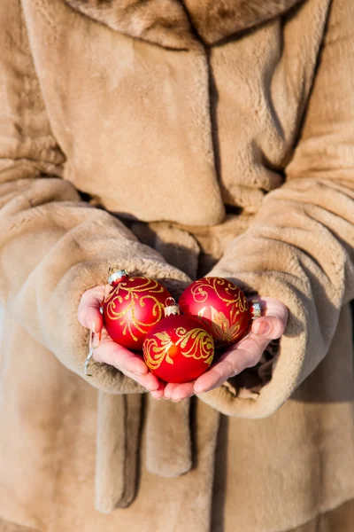 Vrouw met drie rode kerst ballen close-up — Stockfoto