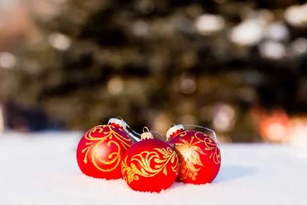 Drie rode kerstballen op een sneeuw. — Stockfoto