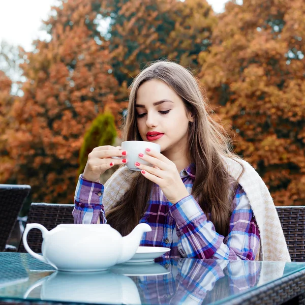 Joven hermosa mujer bebiendo un té en la cafetería al aire libre . — Foto de Stock