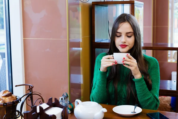 Beautiful young woman drinking tea in cafe — Stock Photo, Image