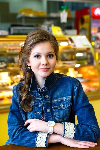 Hermosa chica sonriente con el pelo largo sentado en la cafetería — Foto de Stock