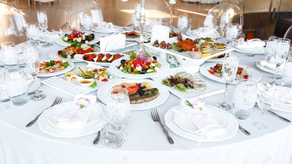 decorated table with meal and tableware at wedding reception 