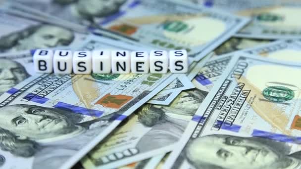 Parola da cubi "tbusiness" sulla superficie filante di dollari americani — Video Stock