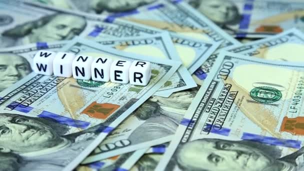 Slovo z krychlí "vítěz" na povrchu rotující amerických dolarů — Stock video