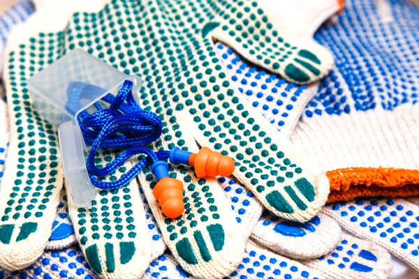 Тонкие рабочие перчатки с зелеными прыщами и затычками для ушей
.