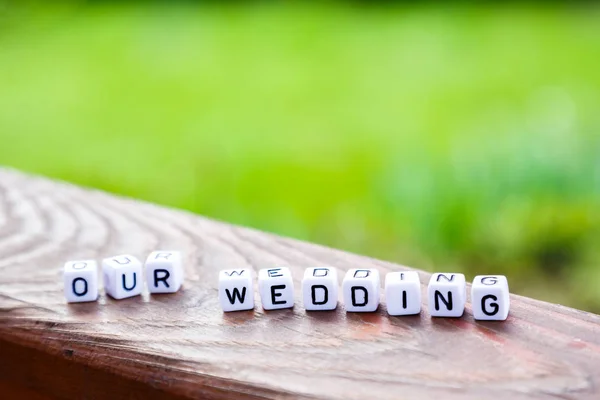 Woord van de kubussen "onze wedding" op een houten tribune — Stockfoto