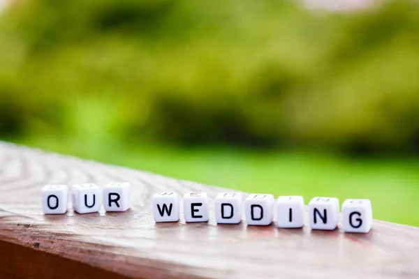 Le mot des cubes "notre mariage" sur un stand en bois — Photo