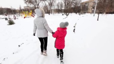 İki kız, anne ve kızı, kış soğuk günde bir parkta yürüyüş.