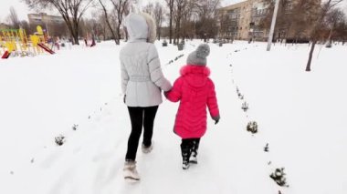 İki kız, anne ve kızı, kış soğuk günde bir parkta yürüyüş.