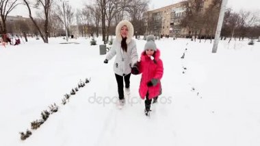 İki kız, anne ve kızı, kış soğuk günde bir parkta yürüyüş.