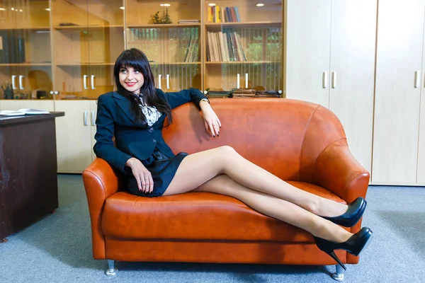 Genç güzel iş kadını ofiste bir kanepe yatan dinlenme — Stok fotoğraf