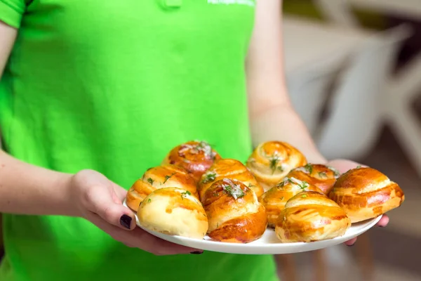 Waitress holding a plate with fresh delicious buns — Stock Photo, Image