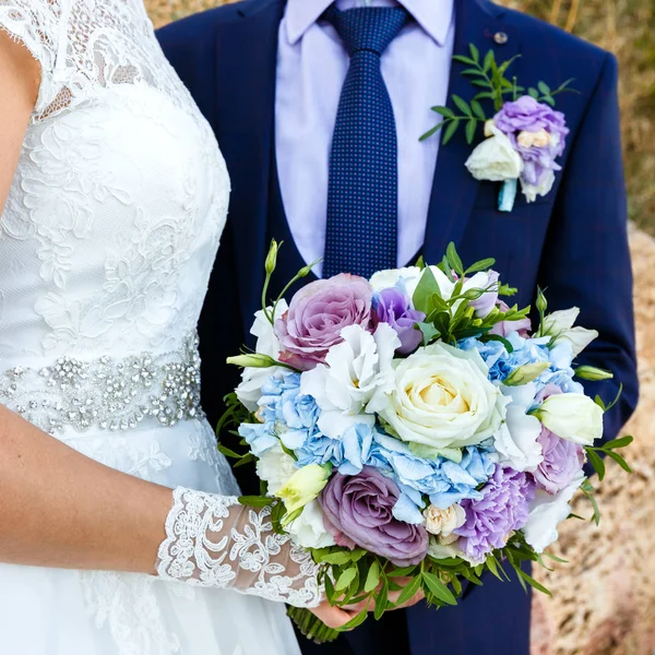 Mariée et marié tenant beau bouquet de roses à l'extérieur . — Photo