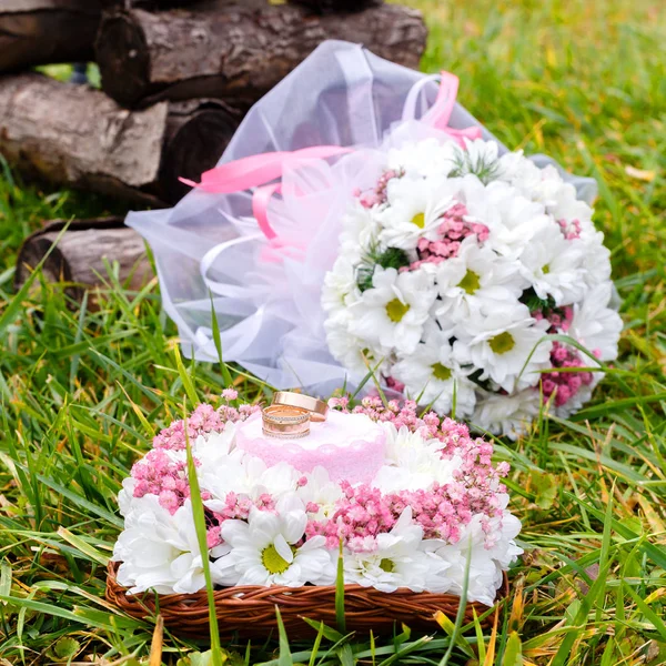 Обручальные кольца на подставке и свадебный букет белого ромашки — стоковое фото