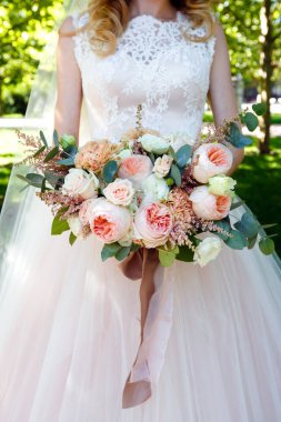 Parkta güzel düğün buket gül tutan gelin.