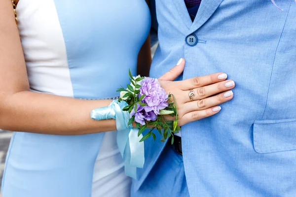 Young woman with floral boutonniere hugging man in blue suit — Stock Photo, Image