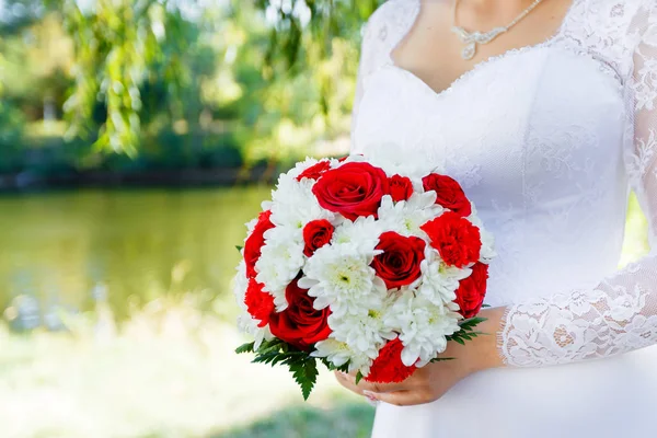 Руки невесты держат свадебный букет близко — стоковое фото