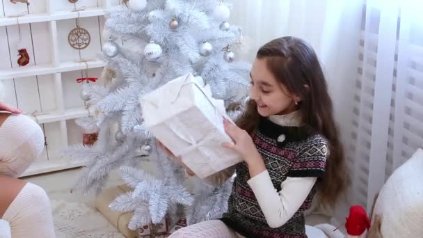 Menina feliz com presente de Natal perto da árvore de Natal em casa . — Vídeo de Stock