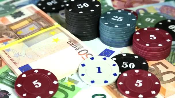 Poker chips en eurobankbiljetten op roterende oppervlak. — Stockvideo