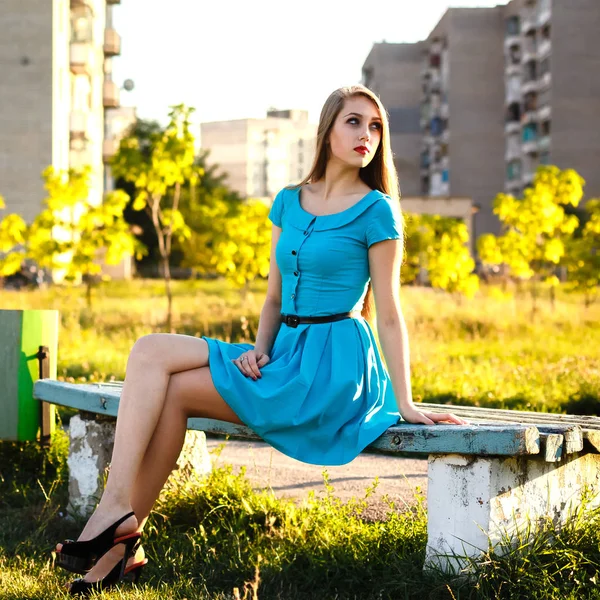 Mulher bonita sentada em um banco em um parque da cidade em ensolarado — Fotografia de Stock