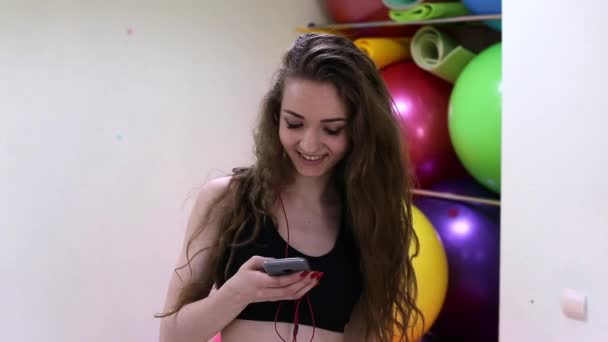 Young cheerful caucasian women listening to music in a fitness club. — Stock Video