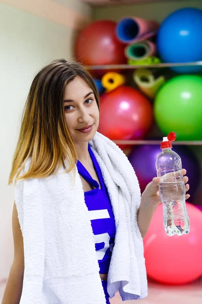 Mujer joven con una toalla sosteniendo una botella de agua —  Fotos de Stock