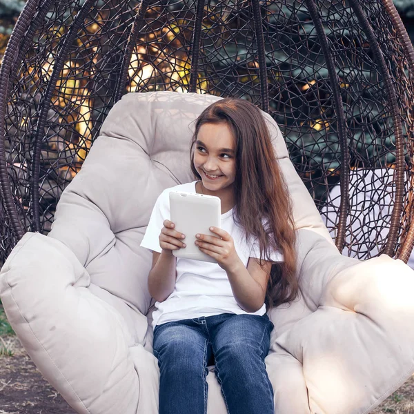 Happy girl tenant tablette PC, assis dans un parc le jour de l'été — Photo